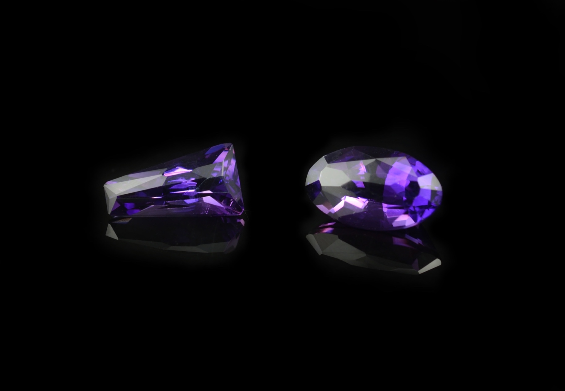 Deep purple amethyst gemstones cut with facets on the top of the stone