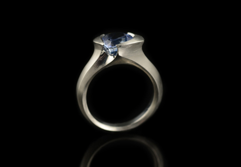 Carved platinum cocktail ring set with a trillion sapphire