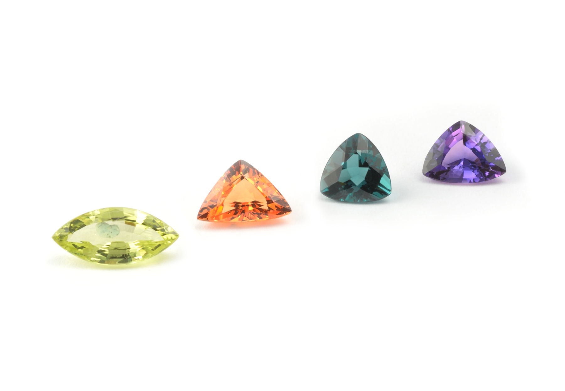Coloured gemstones, chrysoberyl, mandarin garnet, blue tourmaline trillion, and purple sapphire trillion