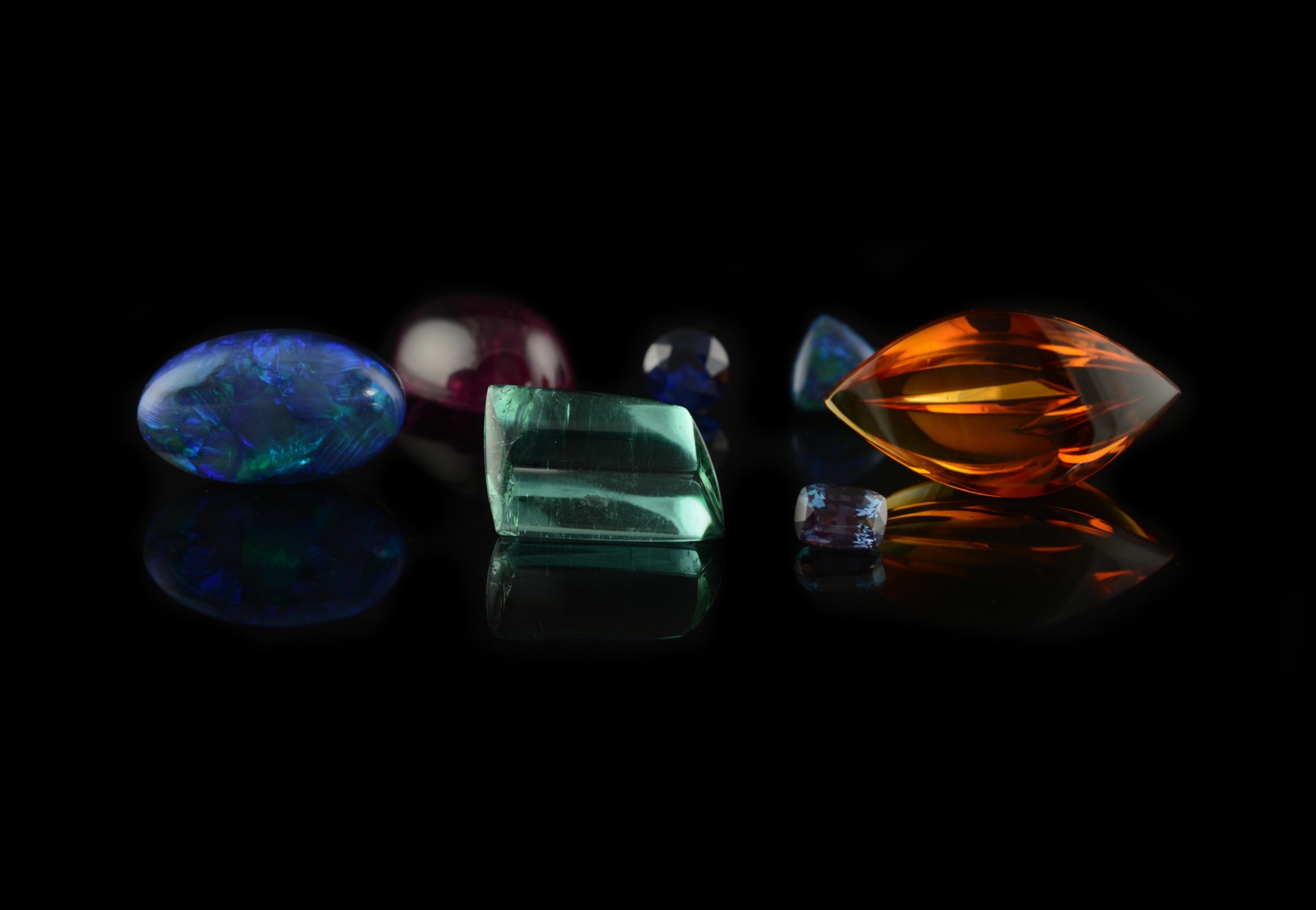 Loose gemstones for commissions: black opal, rubellite tourmaline, White cliffs black opal, sapphire, petrol blue trapezoid tourmaline, citrine, alexandrite