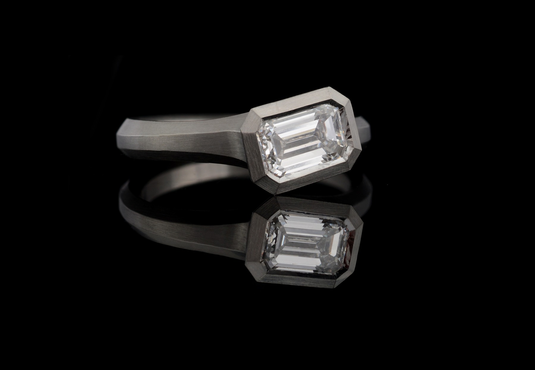 Modern platinum engagement ring with emerald-cut white diamond