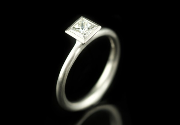 Platinum engagement ring with princess cut diamond and square bezel