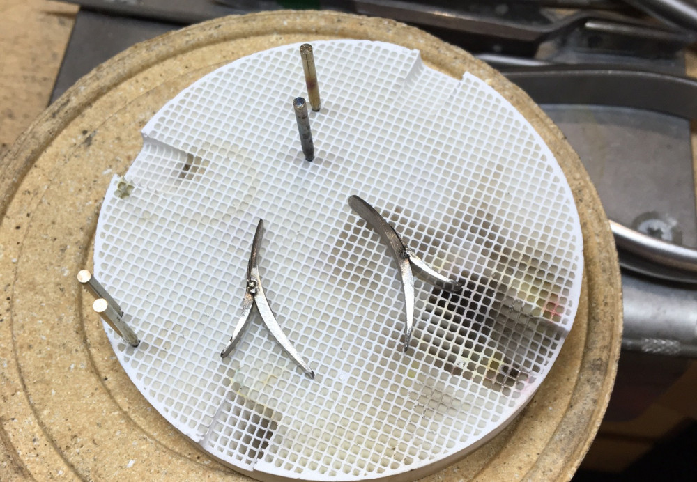 Making hand forged white gold, emerald and diamond earrings