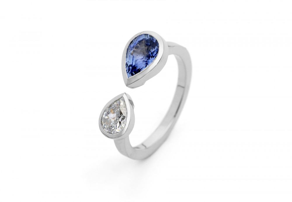 Unusual two stone engagement ring with pear shaped diamond and blue sapphire